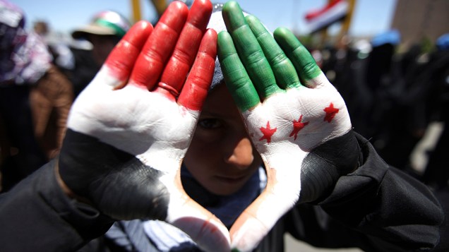 Menina mostra mãos pintadas nas cores da bandeira nacional do Iêmen e da bandeira da oposição síria, durante protesto anti-governo em Sanaa, Iêmen