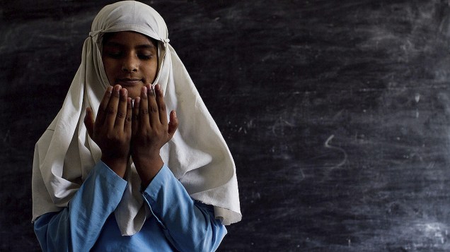 Menina muçulmana reza durante a primeira semana do Ramadã