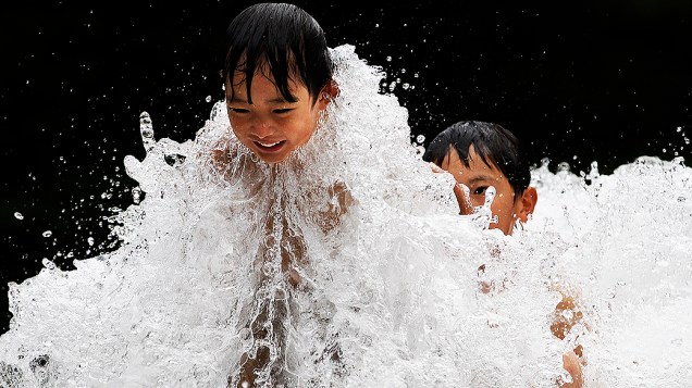 Crianças brincam em fonte de água em Tóquio, no Japão