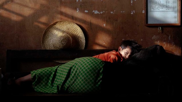 Menino descansa com sua mãe em Mianmar