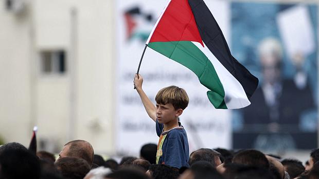 Menino palestino carrega bandeira entre manifestantes