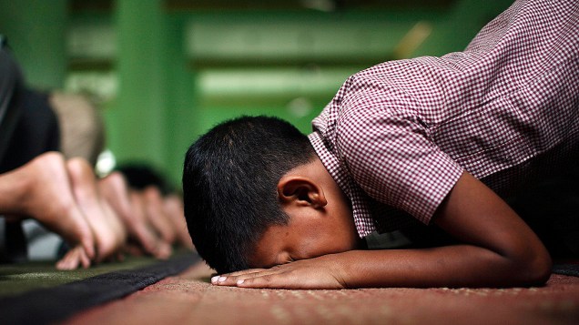 Menino muçulmano faz oração durante o mês sagrado do Ramadã em Katmandu, no Nepal
