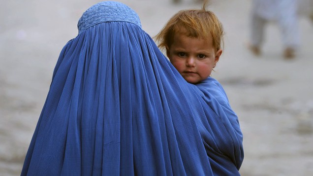 Mulher afegã carrega seu filho na parte velha de Cabul. O país devastado pela guerra ainda enfrenta pobreza, desemprego e falta de infra-estrutura