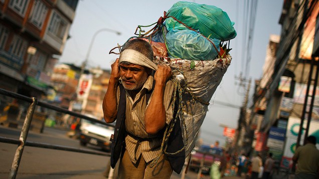 Homem carrega legumes do mercado para um veículo em Kathmandu