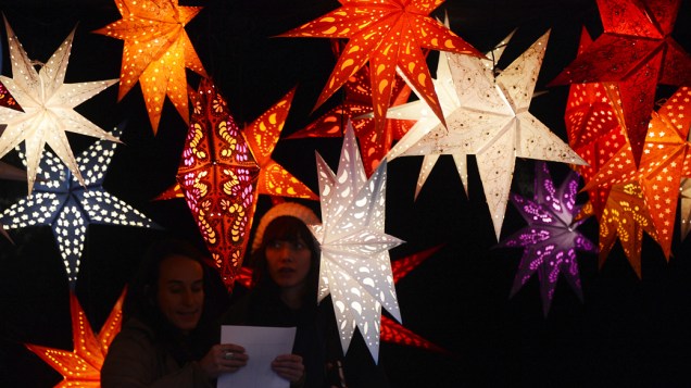 Pessoas entre a decoração em mercado de Natal em Berlim, na Alemanha Pessoas entre a decoração em mercado de Natal em Berlim, na Alemanha