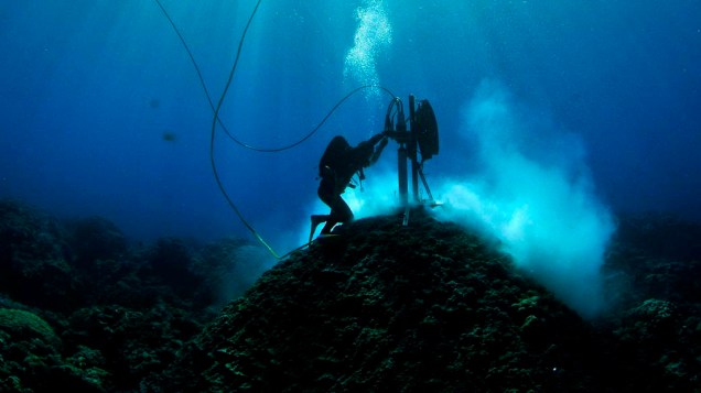 Mergulhador do Instituto de Ciência Marinha Australiana examina corais