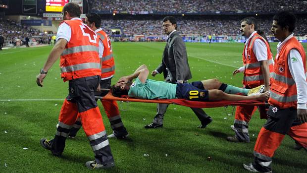 Messi deixa o campo de maca após ser atingido por Tomas Ujfalusi na partida contra o Atlético de Madrid