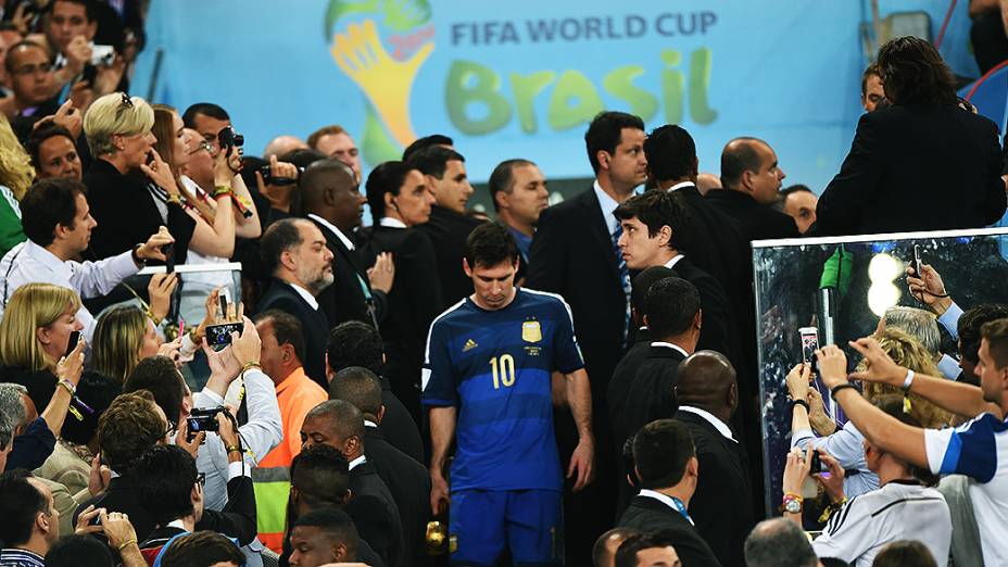 Lionel Messi pega o troféu de melhor jogador da Copa de cabeça baixa, após perder da Alemanha na final da Copa no Maracanã, no Rio