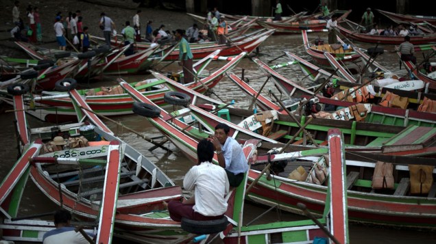 Barqueiros aguardam passageiros em Yangon, Mianmar