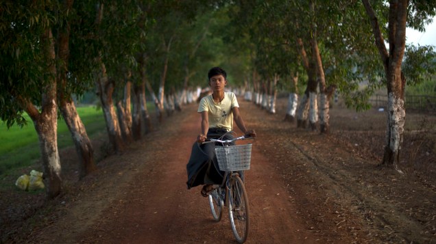 Garoto anda de bicicleta próximo a campos de arroz na cidade de Bago, ao norte da capital Yangon, Mianmar