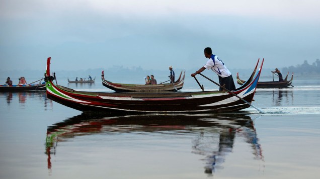 Turistas ocidentais passeando de barco no lago Taungthaman na cidade de Mandalay ao norte de Mianmar