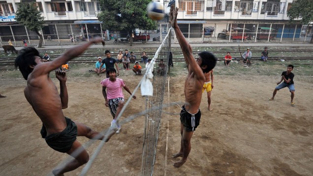 Homens jogam vôlei ao lado da ferrovia em Myitkyina, no estado de Kachin ao norte de Mianmar