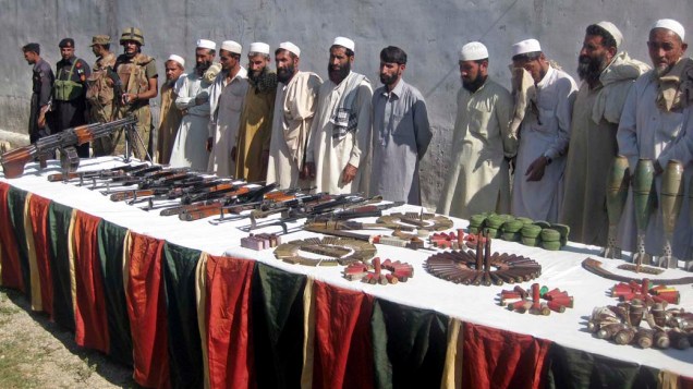 Membros da milícia talibã Qari Zia entregam seus armamentos à polícia em Bajaur, no Paquistão