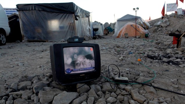 Em acampamento onde familiares esperam por notícias dos mineiros, televisão mostra a imagem dos trabalhadores presos na mina que desmoronou em San José, Chile