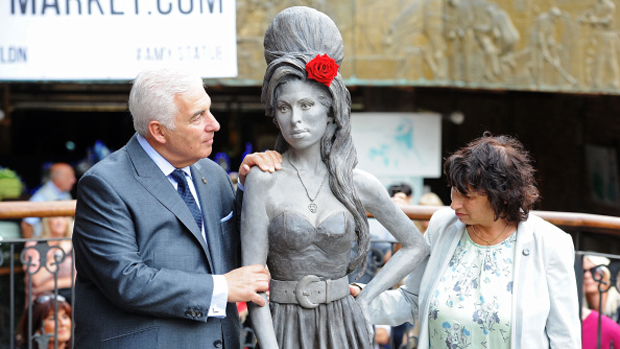 Mitch e Janis Winehouse ao lado da estátua da filha, Amy Winehouse, em Londres