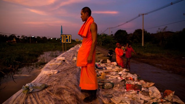 Monge descansa após trabalho de fortificação de barragem contra enchentes em Bangcoc, na Tailândia