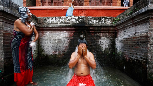 Moradores locais tomam banho em fonte de Lalitpur, no Nepal