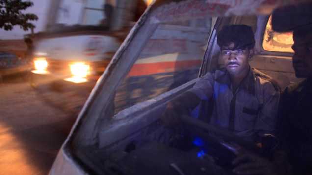 Motorista de transporte público aguarda a entrada de passageiros em Daca, Bangladesh