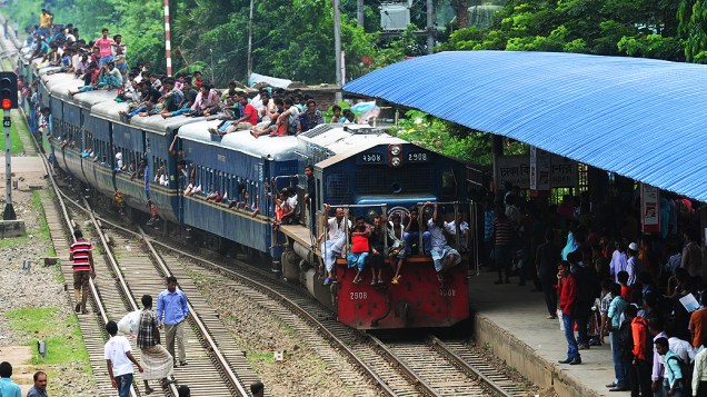 Trem superlotado se aproxima de estação em Daca, em Bangladesh. Anualmente, bengaleses muçulmanos deixam a capital do país em direção a vilarejos para celebrar com seus familiares o festival Eid al-Fitr, que marca o encerramento do mês sagrado do Ramadã