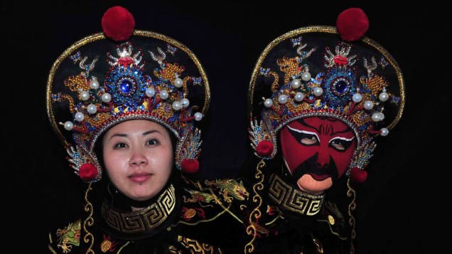 Em Shenyang, China, atriz mostra a prática de "mudança de rosto" feita com máscaras em óperas chinesas
