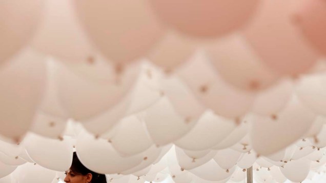Mulher se prepara para soltar balões durante celebrações de fim de ano em São Paulo, Brasil