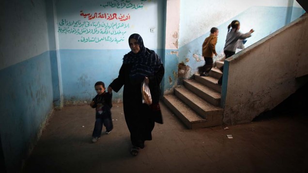Mulher caminha com seu filho em seção eleitoral durante o segundo dia de votação no Cairo, Egito