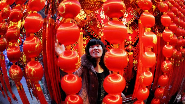 Chinesa escolhe lanternas em mercado preparado para vendas das celebrações de Ano Novo em Yiwu, China