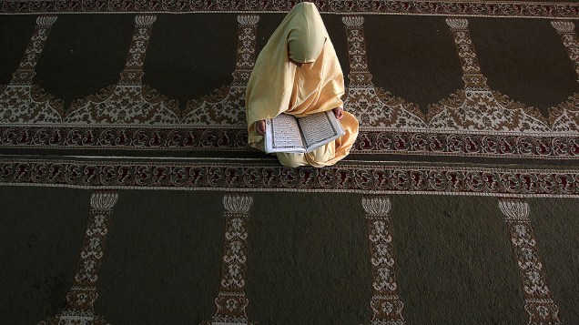 Menina palestina lê versos do Alcorão o livro sagrado do Islã, em um acampamento na Cidade de Gaza