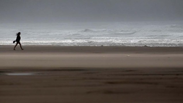 Mulher na praia Rhossili no País de Gales, que está sofrendo com o furacão Katia