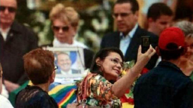 Mulher tira foto ao lado do caixão de Eduardo Campos