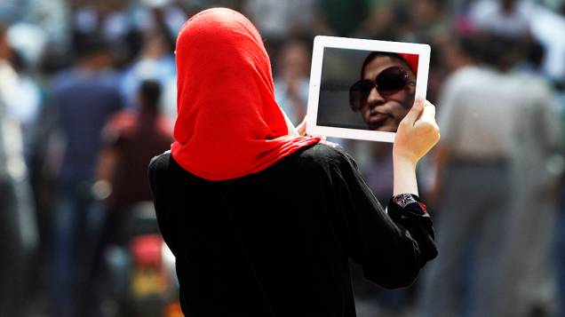 Mulher egípcia usa o seu tablet durante manifestação no marco do Cairo Tahrir Square