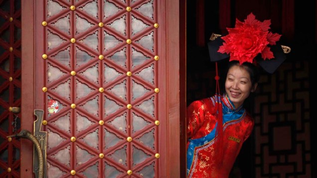 Garçonete vestida com roupas tradicionais da dinastia Qing em restaurante em Pequim, China