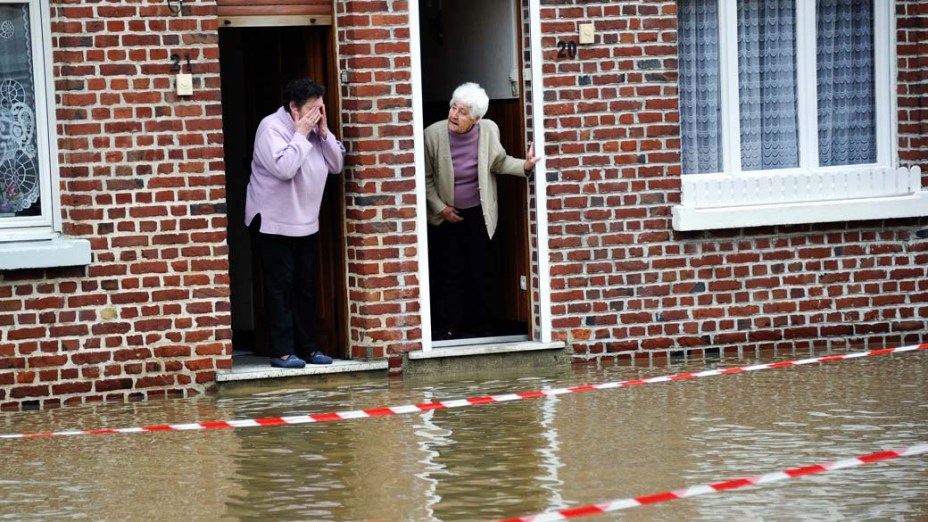 Mulheres observam nível da água após enchente causada por chuva e neve em Steenwerck, norte da França