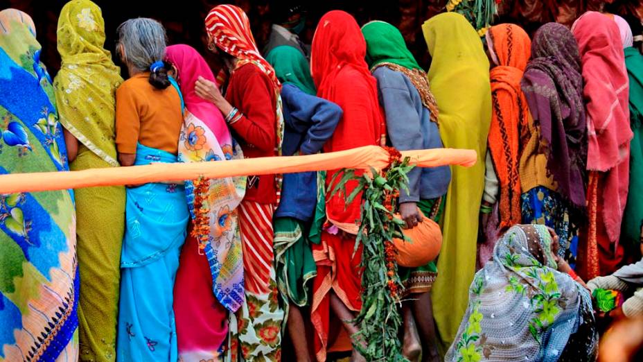 Mulheres aguardam distribuição de alimentos durante a celebração hindu “Makar Sankranti”, Índia