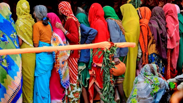 Mulheres aguardam distribuição de alimentos durante a celebração hindu “Makar Sankranti”, Índia