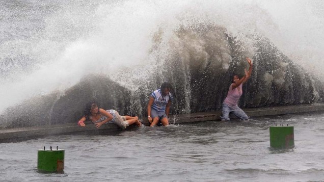 Em Manila, Filipinas, ondas ultrapassam paredão na comunidade costeira de Navotas. Ao menos nove pessoas morreram nas inundações e deslizamentos de terra provocados pela tempestade tropical Aere