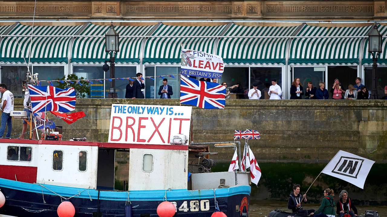 Barco com bandeiras contra a permanência do Reino Unido na União Europeia, é seguido por um bote com uma bandeira à favor, em Londres