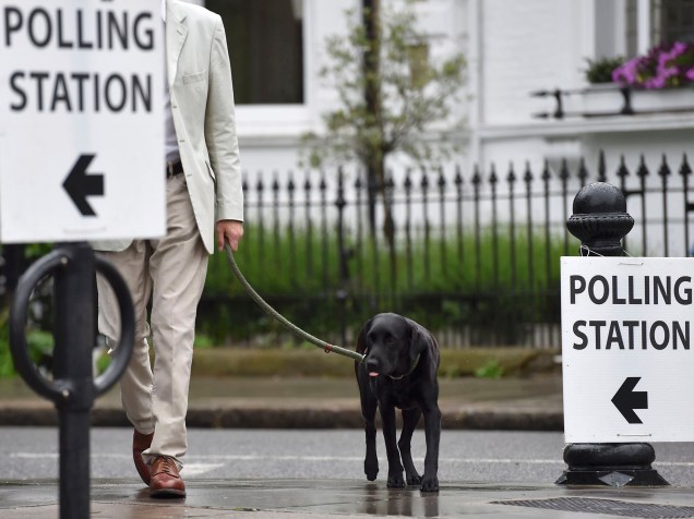 Homem chega para votar o referendo com seu cachorro, em Londres