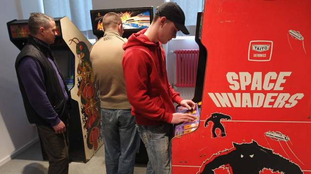 Visitantes jogam Centipede e Space Invaders, no Museu de Jogos de Computador em Berlim