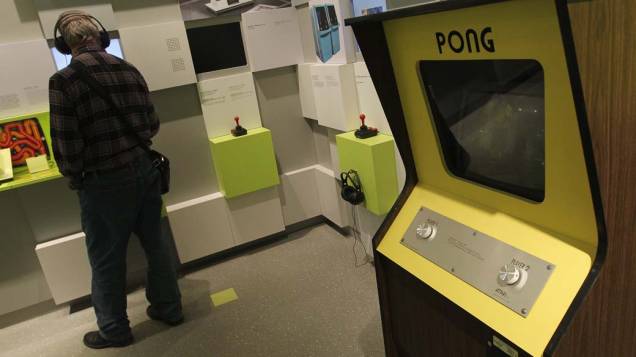 Visitante escuta uma apresentação ao lado do console Pong, um dos jogos mais antigos, no Museu de Jogos de Computador em Berlim