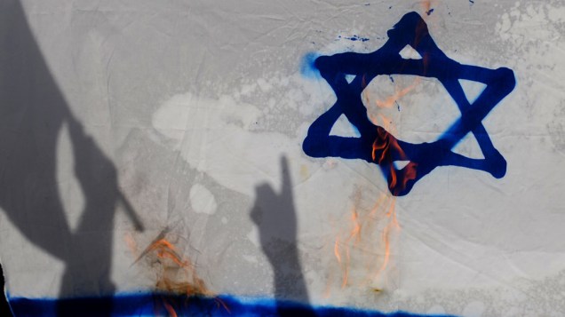 Manifestantes atearam fogo em uma bandeira israelense durante protestos que marcaram a celebração do Nakba, em Istambul. A data marca a criação de Israel e o exílio de 760 mil palestinos - 15/05/2011