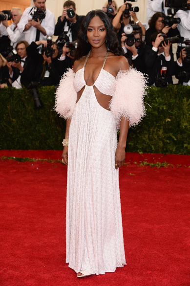 Naomi Campbell engrossa a lista das mais mal vestidas do MET 2014 com o look branco de penas