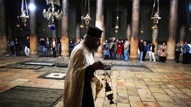 Sacerdote ortodoxo caminha no interior da Igreja da Natividade, reverenciada pelos cristãos como local de nascimento de Jesus, em Belém