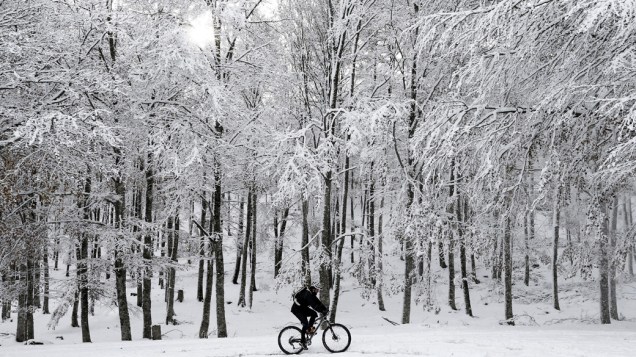 Um ciclista tenta subir uma ladeira coberta de neve, em Navarra na Espanha
