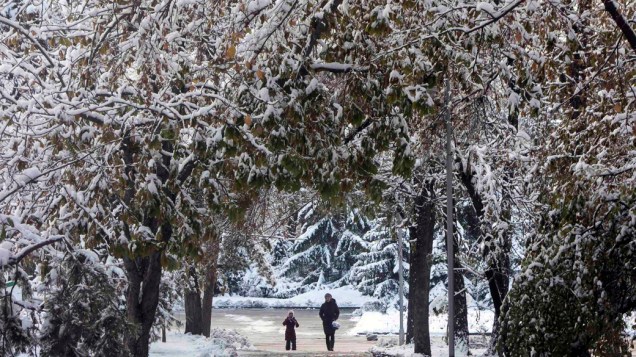 Pessoas caminham em um parque coberto de neve, em Almaty no Cazaquistão