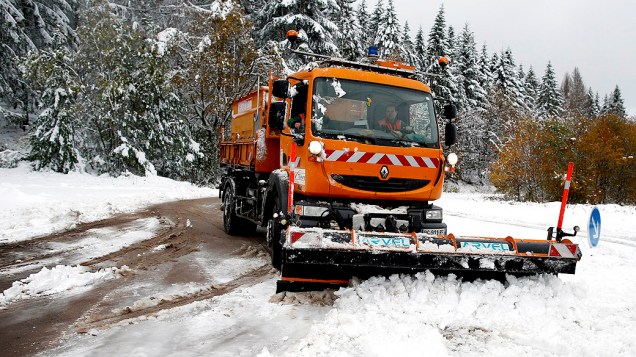 Um caminhão tira a neve que cobriu uma estrada na região da Borgonha, na França