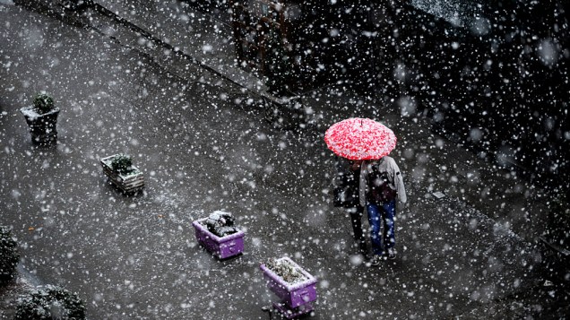 Casal passeia sob a neve, em Kosovo
