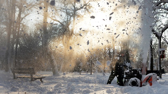 Trabalhador remove neve acumulada em parque, na Romênia