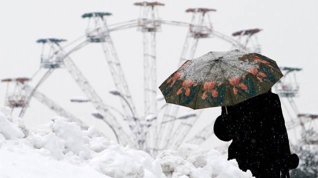 Uma mulher anda com um guarda-chuva durante forte nevasca em Kiev, na Ucrânia