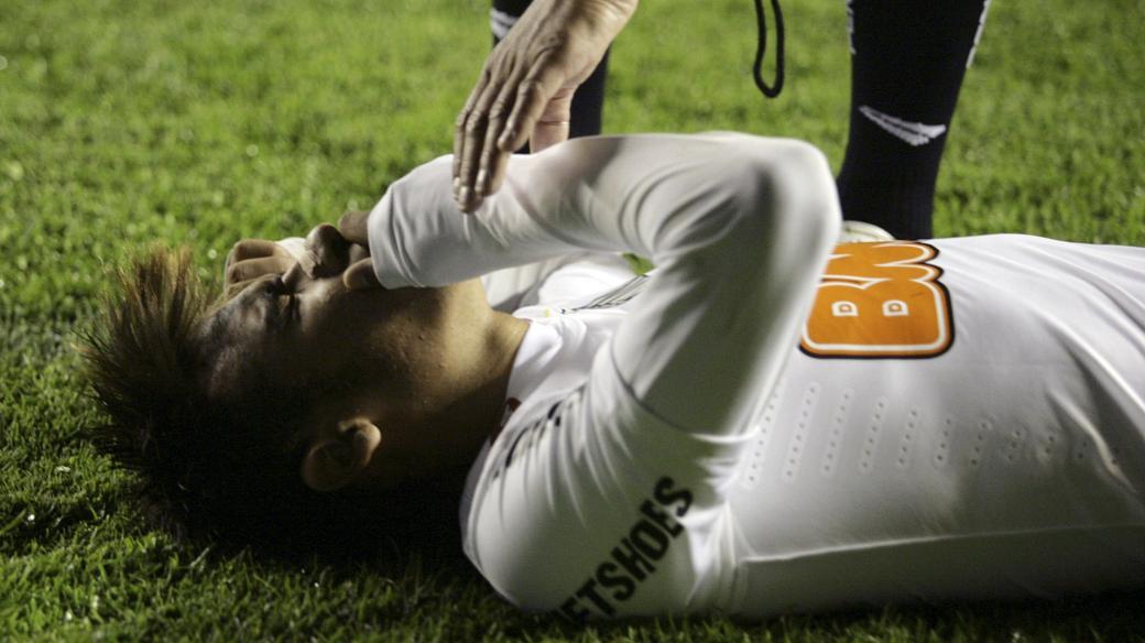 Neymar, do Santos, caído no gramado após ser atingido por objetos jogados pela torcida do Bolívar, em La Paz, no jogo de ida das oitavas de final da Libertadores 2012